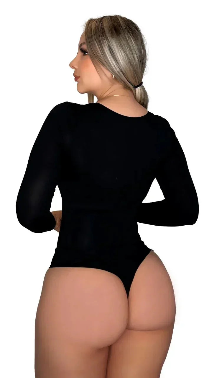 Mujer rubia de perfil con bodysuit negro de manga larga destacando figura y estilo moderno