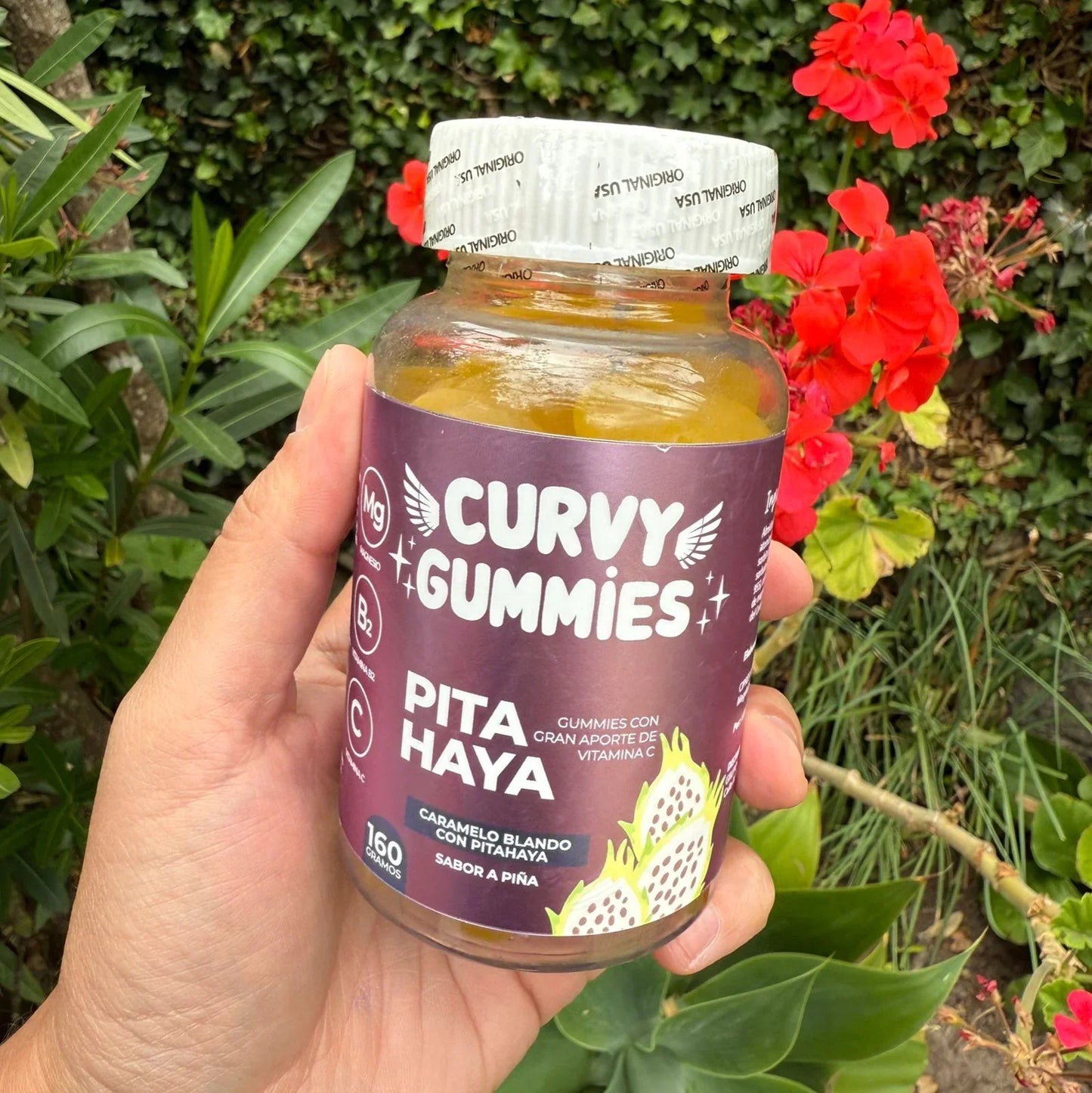 Mano sosteniendo botella de Curvy Gummies Pitahaya sabor piña